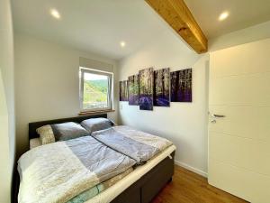 a bedroom with a bed and two paintings on the wall at Sky Apartment, Sauna, Blick zur Mosel, großer Balkon, Kaffeemaschine, Smart TV in Zell an der Mosel