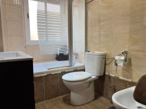 un bagno con un water, un lavandino e una finestra di Piso familiar con perfecta ubicación a Cordoba Altre 18 foto