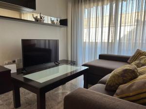 un soggiorno con un divano, una TV e un tavolo di Piso familiar con perfecta ubicación a Cordoba