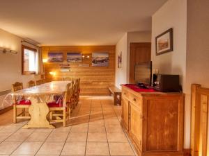 a dining room with a table and a television at Spacieux Appartement 4 Chambres Pieds des Pistes à Morillon 1100 - FR-1-642-4 in Morillon