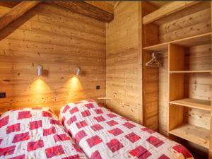 een slaapkamer met een bed in een houten kamer bij Chalet Morillon 1100, 6 pièces, 12 personnes - FR-1-642-5 in Morillon