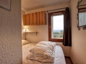 a small bedroom with a bed and a window at Appartement Morillon 1100, 3 pièces, 6 personnes - FR-1-642-15 in Morillon