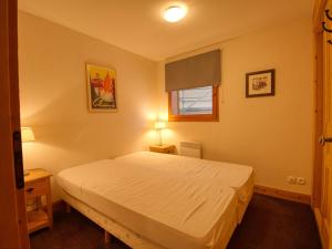 a bedroom with a white bed and a window at Appartement Morillon 1100, 3 pièces, 7 personnes - FR-1-642-44 in Morillon