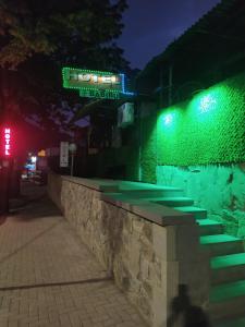 a stone wall with green lights on a street at Babibu in Mtskheta