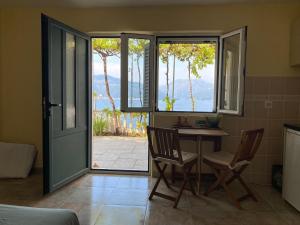 Habitación con mesa, sillas y puerta corredera de cristal. en Villa Miran Boka Bay, en Krasići