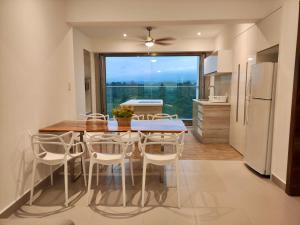 uma cozinha e sala de jantar com mesa e cadeiras em Departamentos frente al mar Resort Playa Azul em Tonsupa