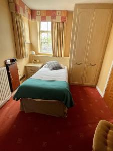 a bedroom with a bed and a window at Donington Manor Hotel in Castle Donington