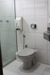 a bathroom with a toilet and a shower at Hotel Mirage in Vilhena