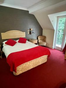 a bedroom with a large bed with a red blanket at Donington Manor Hotel in Castle Donington
