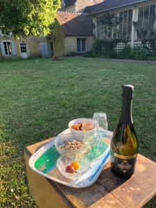 een tafel met een fles wijn en een bord eten bij Charming Normandy Country Home in Condeau +13 foto's