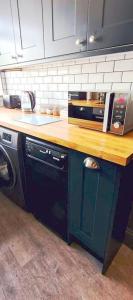 a kitchen with a wooden counter top and a dishwasher at The Wolf's Den in Patrington