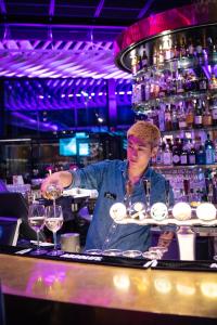 a man standing behind a bar with a tray of wine glasses at Quality Hotel Globe in Stockholm