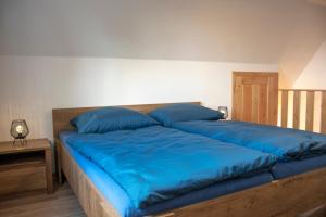 a large bed with blue sheets and pillows on it at Chata Na Vyhlídce in Železnice
