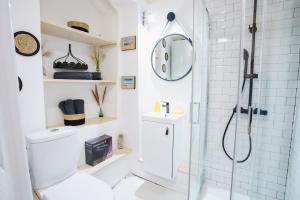 a white bathroom with a shower and a toilet at La Villa Au petit bonheur in Honfleur
