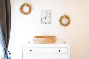a white dresser with two wreathes and two mirrors at La Villa Au petit bonheur in Honfleur