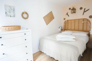 a bedroom with a bed and a dresser at La Villa Au petit bonheur in Honfleur