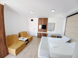 um pequeno quarto com uma cama e um sofá em RIBAR APARTMENTS em Ohrid