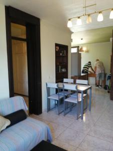 a living room with a table and chairs and people at Primavera appartement tot 7 personen in Arona