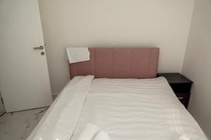 a bed in a small room with a white bedsheet at Royal apartments in Bajina Bašta