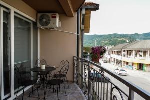 a balcony with a table and chairs and a view of a street at Royal apartments in Bajina Bašta