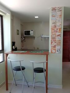 uma cozinha com dois bancos de bar num balcão em Cantinho Aconchegante 306 Praia - Tambaú 2 em João Pessoa