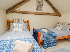 a bedroom with two beds and a chair at Buzzards Breg in Builth Wells