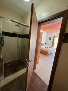 a bathroom with a shower and a glass door at All Nations Holiday Home in Għajnsielem