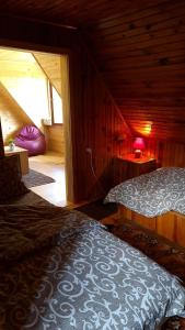 - une chambre avec 2 lits dans une cabane en bois dans l'établissement Miliceva ruza, à Zlatibor
