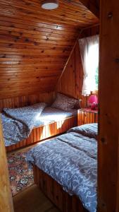 2 Betten in einem Zimmer mit Holzwänden in der Unterkunft Miliceva ruza in Zlatibor