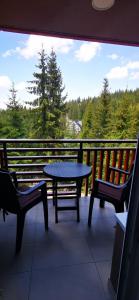 a patio with a table and two chairs on a balcony at Apartman ALTA in Vlasic