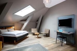 a bedroom with a bed and a desk and a tv at Comfort Hotel Børsparken in Oslo