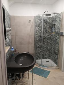a bathroom with a shower with a black sink at Le Cassiere DNA in Roccalumera