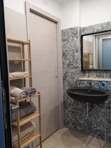 a bathroom with a black sink and a mirror at Le Cassiere DNA in Roccalumera