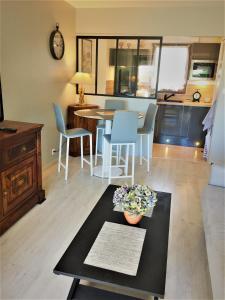 a living room with a table and chairs at Domaine privé, , piscine, jacuzzi, joli appartement in Deauville