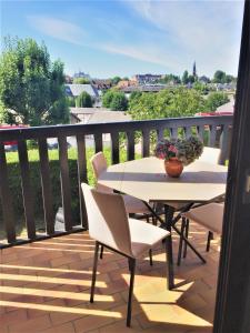 a patio with a table and chairs on a balcony at Domaine privé, , piscine, jacuzzi, joli appartement in Deauville