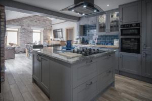 a kitchen with gray cabinets and a counter top at Bayview House - 4 Bedroom Luxurious Holiday Home - Saundersfoot in Saundersfoot
