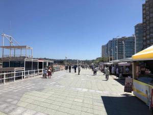 ヒホンにあるArena Playa Gijón by Flowhomeの街の桟橋を歩く人々
