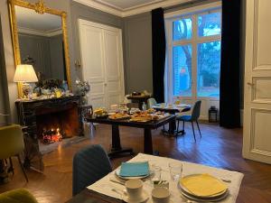 uma sala de jantar com uma mesa e uma lareira em La Grande Carrée em Saint-Cyr-sur-Loire