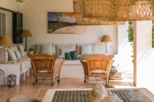 ein Wohnzimmer mit 2 Stühlen und einem Tisch in der Unterkunft Sa Boga in Cap d'en Font