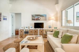 ein Wohnzimmer mit einem weißen Sofa und einem TV in der Unterkunft Sa Boga in Cap d'en Font