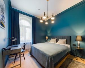 里加的住宿－Aparthotel Amella，一间卧室设有蓝色的墙壁、一张床和一张书桌