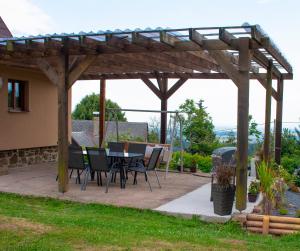 a patio with a table and chairs under a wooden pergola at Chata Na Vyhlídce in Železnice