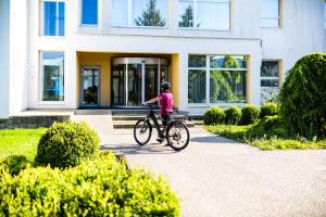 魯哈科維斯的住宿－Nivamare，一名年轻女孩在房子前面骑着自行车