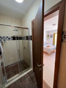 bagno con doccia e porta in vetro di All Nations Holiday Home a Għajnsielem