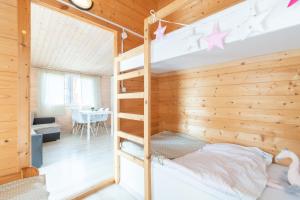 a bedroom with a bunk bed and a dining room at Domki Marina Rowy in Rowy