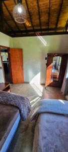 a bedroom with two beds and a wooden ceiling at Chácara Brisa Do Rio in Nova Friburgo