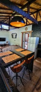 a kitchen with a table with chairs and a refrigerator at Chácara Brisa Do Rio in Nova Friburgo