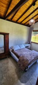 a bedroom with a bed and a large window at Chácara Brisa Do Rio in Nova Friburgo