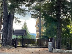 une clôture noire avec un arbre et un bâtiment dans l'établissement NadSan Mountain House, à Camigliatello Silano