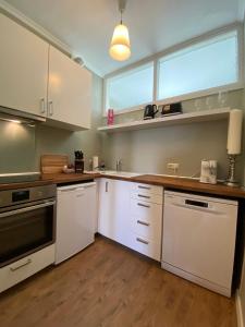 a kitchen with white cabinets and a large window at Zentraler Altbaucharme mit Blick über die Stadt in Kiel